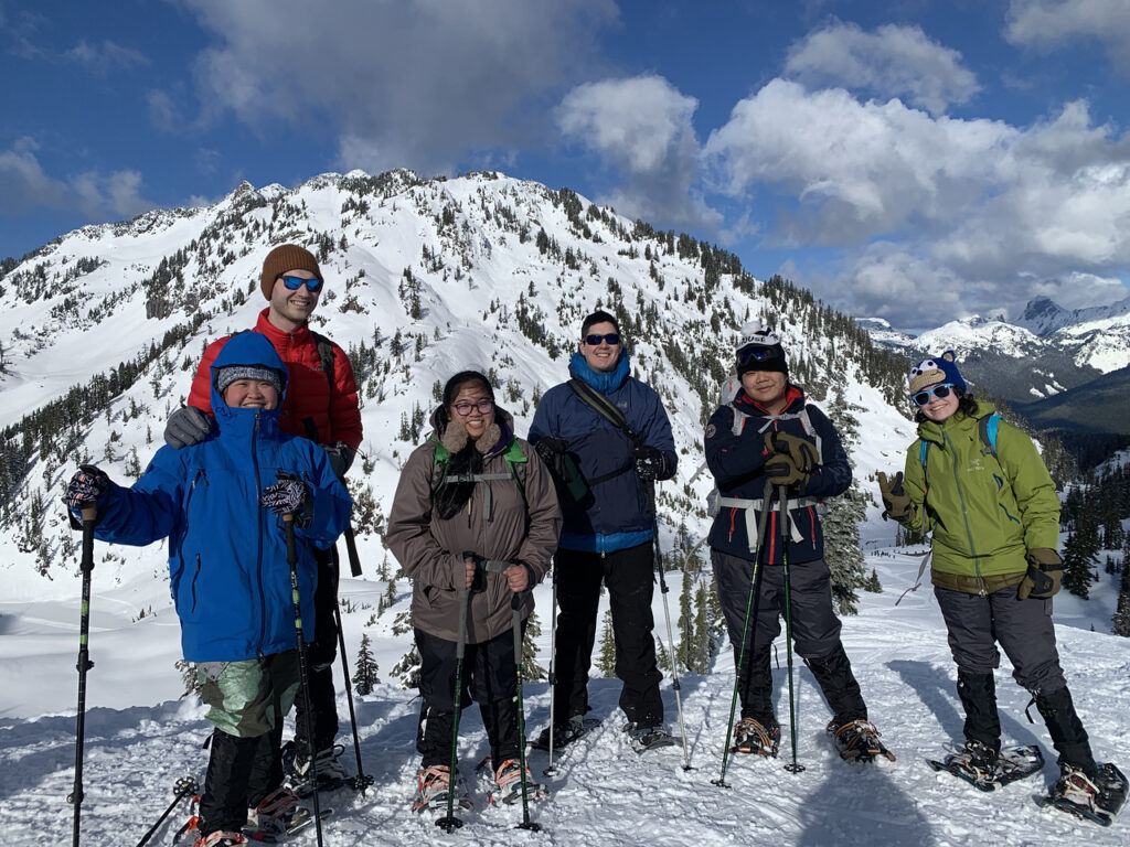 Ŷĳs on snowshoes posing in front of a snowy mountain at Mount Baker