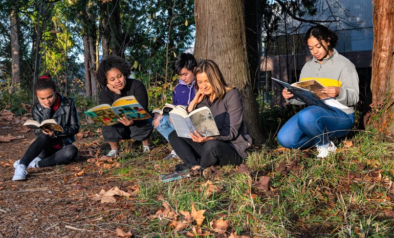 Ŷĳs with books in forest.